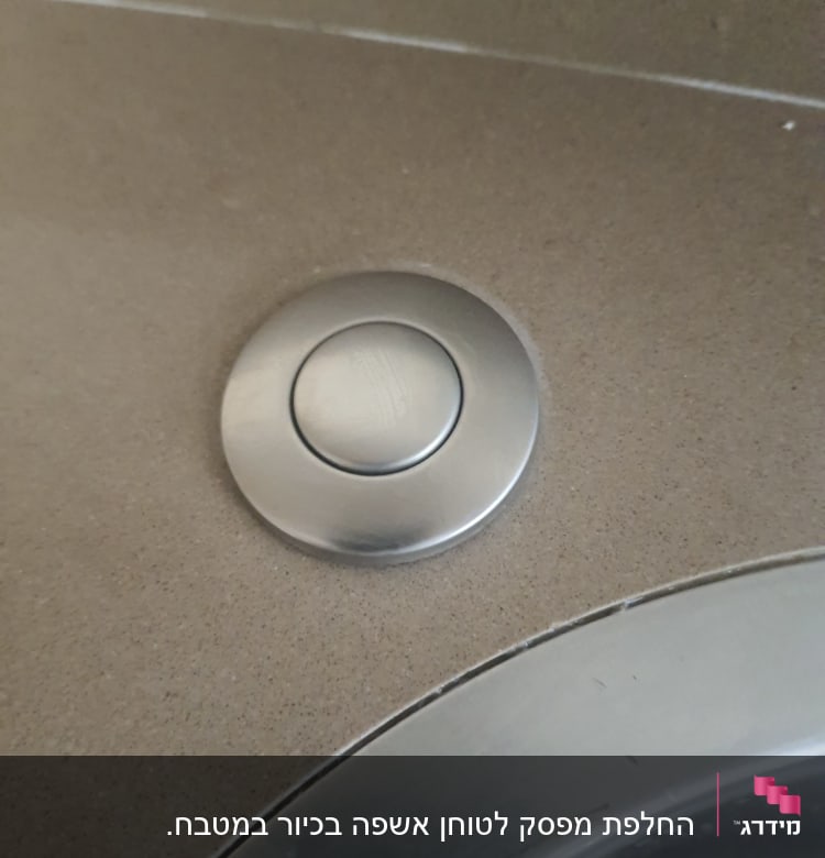 כפתור מתכת עגול על משטח כיור